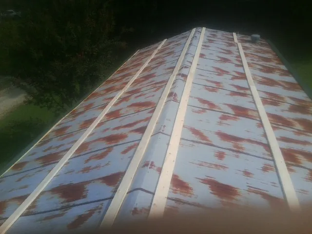 Rusted metal roof panels with new wood purlins before replacement — Storm Damage Roof Repair in Ellenton by Roofing Brothers