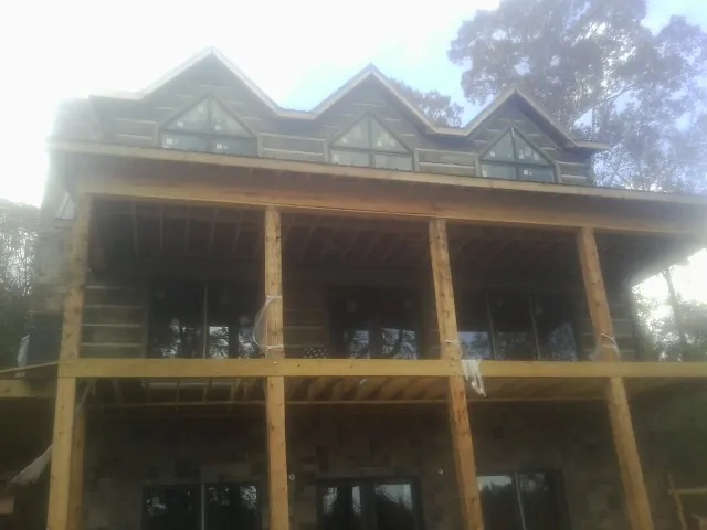 Dormers and porch framing on a large log home under construction — Roof Coating work by our crew in Ellenton