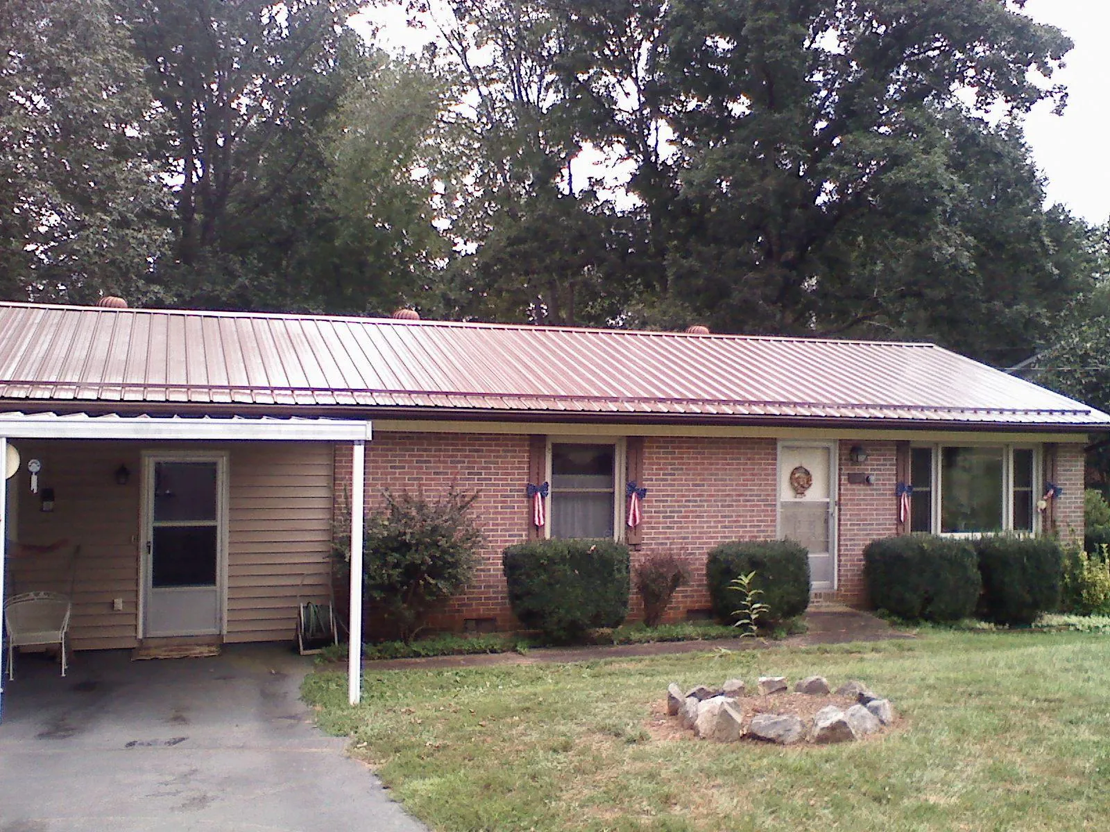 Bronze metal roof and carport on a brick ranch home — Roof Repair work by our crew in Ellenton